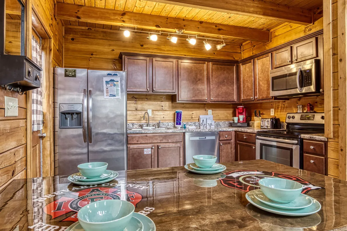 A modern kitchen with a spacious island, stainless steel appliances, and rich wooden cabinets. The layout encourages both cooking and entertaining, with ample room for meal prep and informal gatherings.